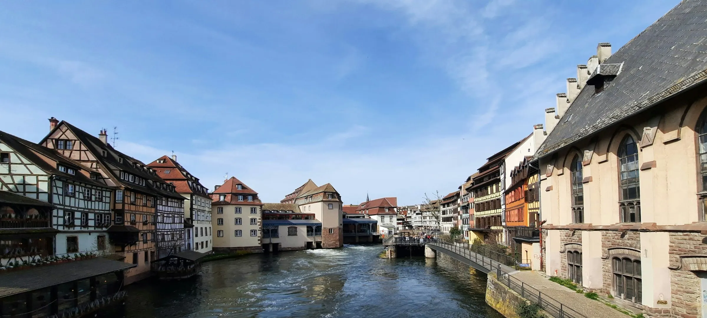 The Ill river running through Strasbourg Petite France, timbered houses and the old customs house under a wide sky