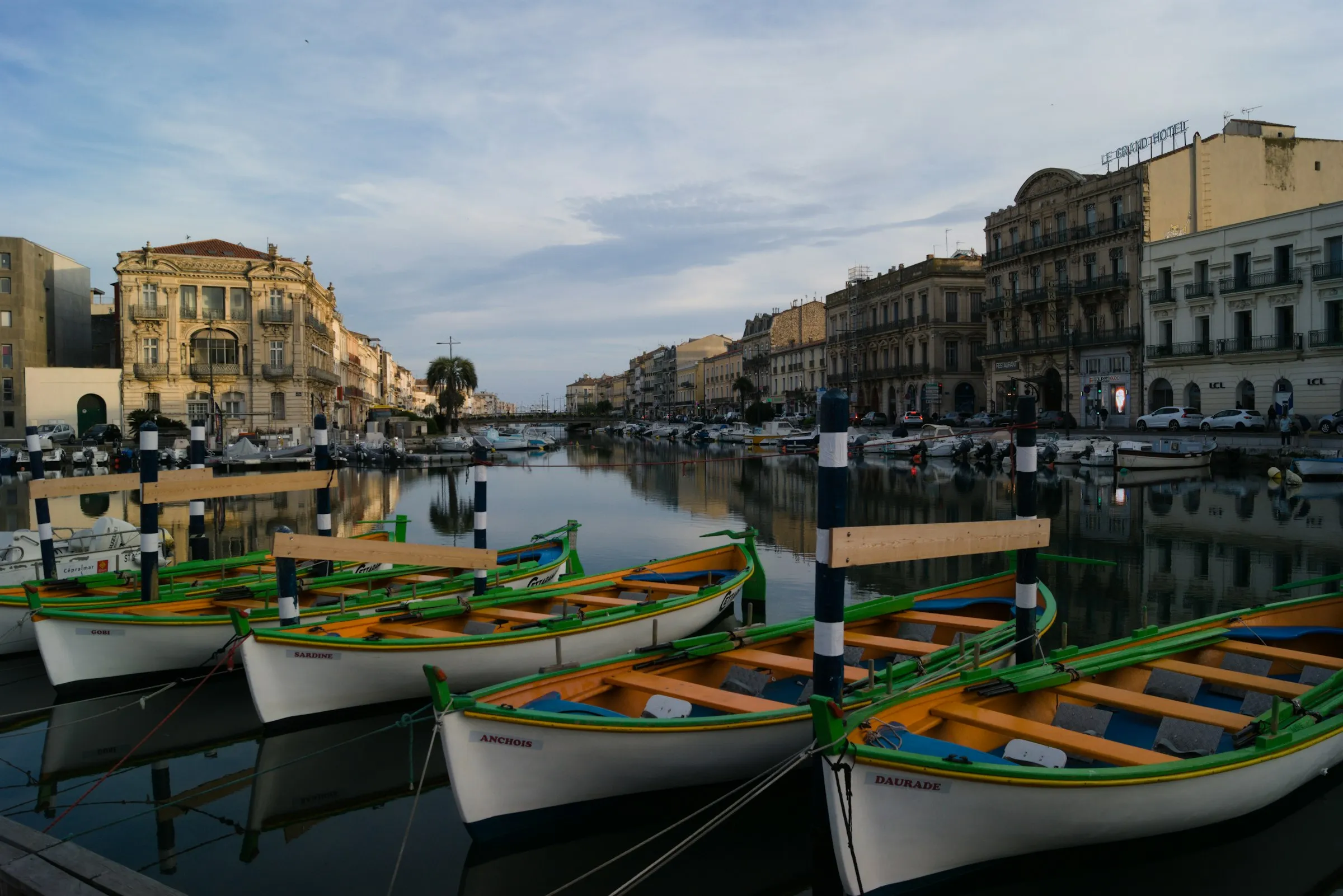 The Canal Royal in Sete lined with moored fishing boats and tall colourful quayside houses, the Venice of Languedoc