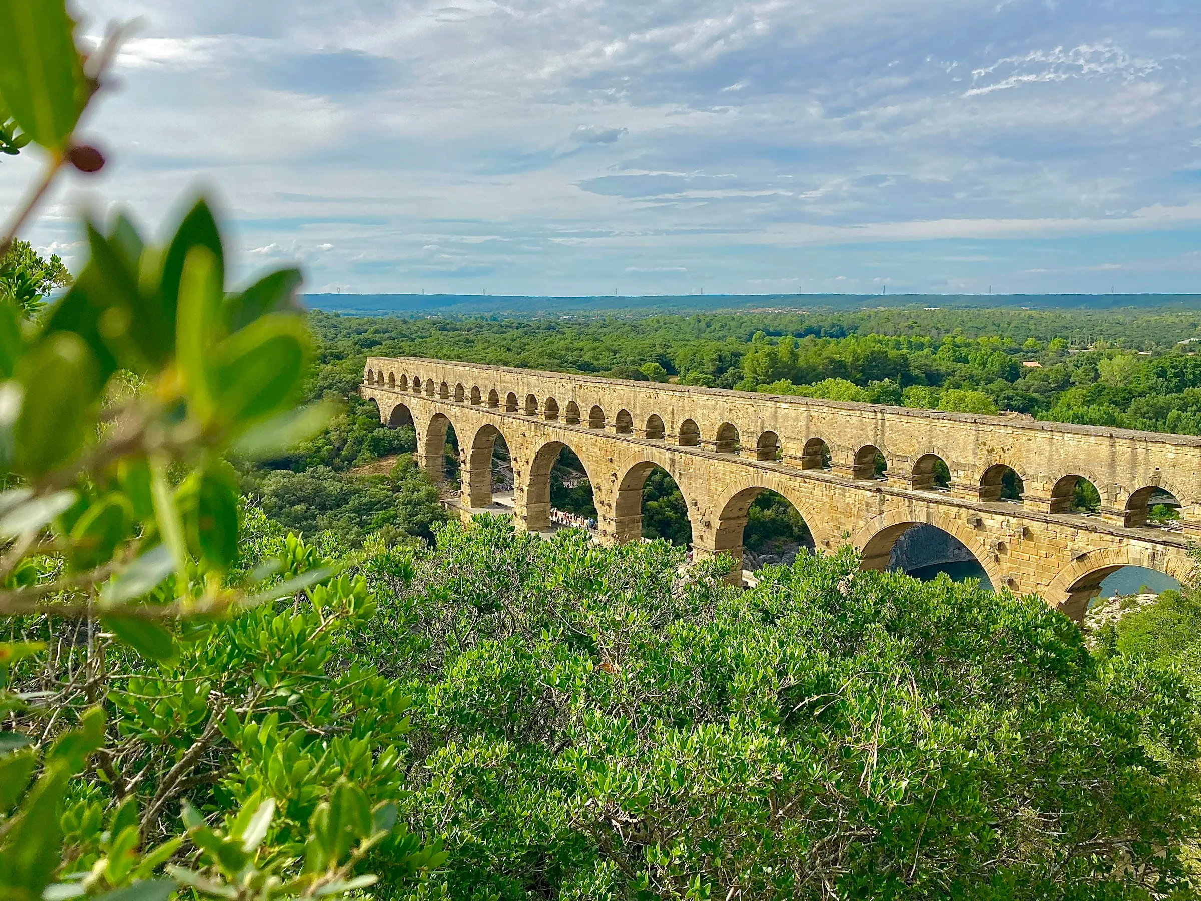 The Pont du Gard, the three-tiered honey-stone Roman aqueduct striding across the wooded Gardon valley under a wide sky, a short drive from Uzès