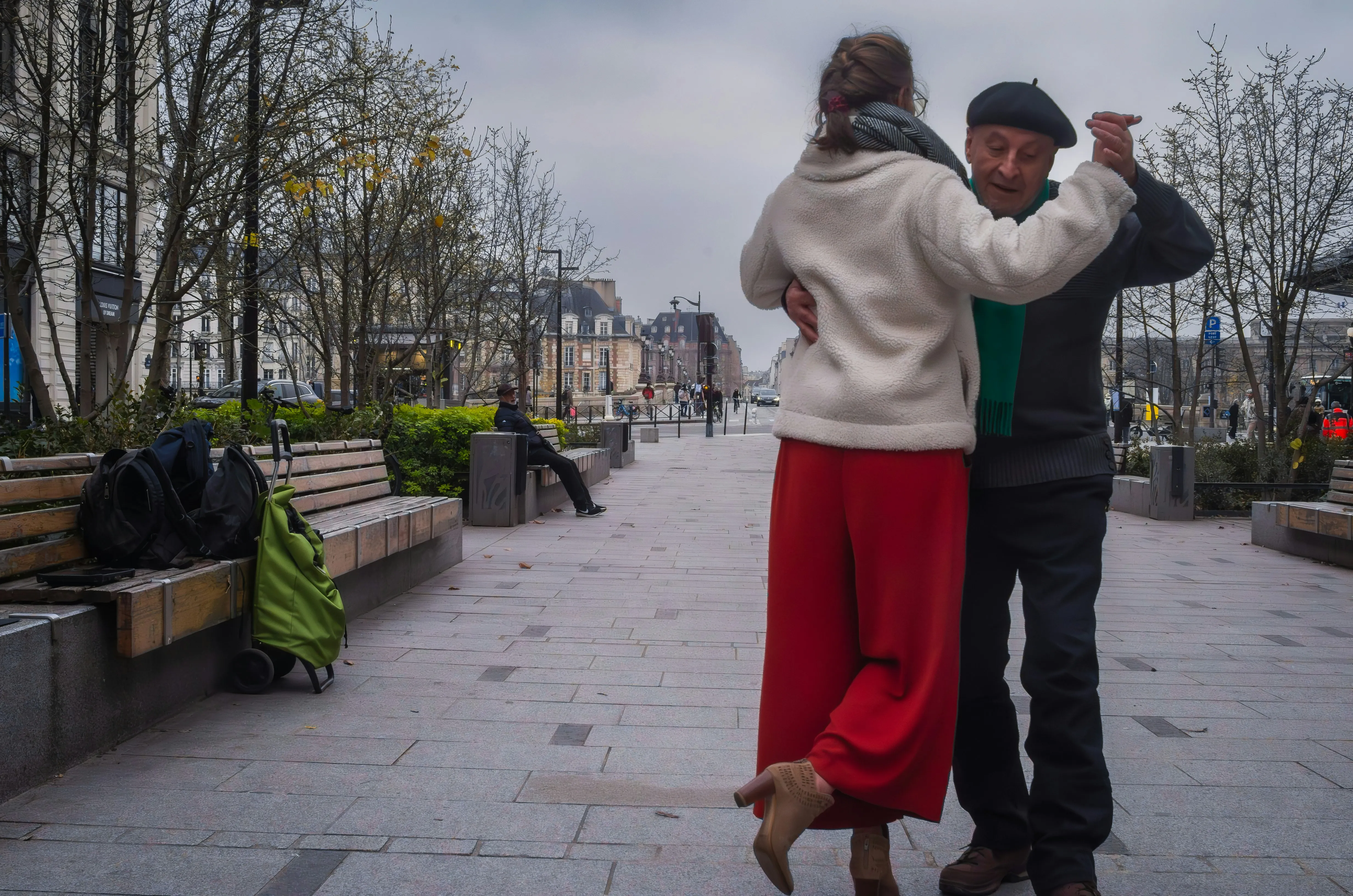A couple dancing together on a Paris square on an overcast morning